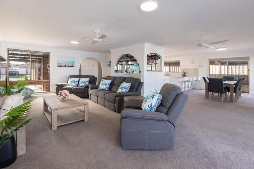 un salon avec deux canapés et une table dans l'établissement Waterfront on Forster Keys, à Forster