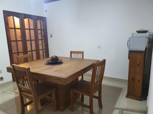 una mesa de madera y sillas en una habitación en Uriburu B&B en Resistencia