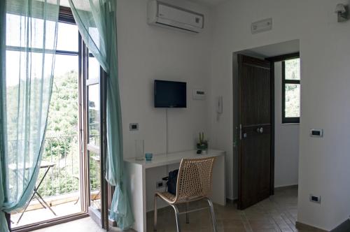 Cette chambre dispose d'un bureau, d'une télévision et d'une fenêtre. dans l'établissement Residence Zelzar, à Vietri