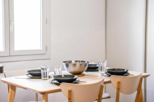 - une table à manger avec des bols et des assiettes dans l'établissement Le Panier II - Appartement au coeur du Panier, à Marseille