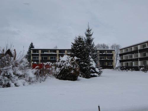 a snow covered parking lot in front of a building at Ferienwohnung Breitenbergblick in Pfronten