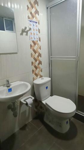 a bathroom with a toilet and a sink at Hotel Libano Center in Pasto