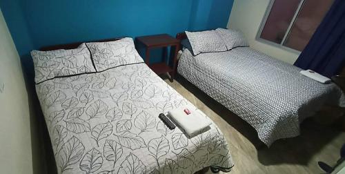 um quarto com 2 camas e um controlo remoto em Hotel Libano Center em Pasto
