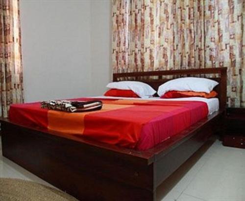 a bedroom with a large bed with a red blanket at Calabash Green Executive Apartments in Accra