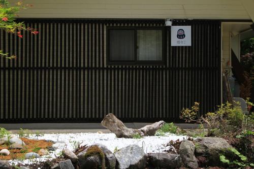 a building with a window and a pile of rocks at 嬉々の屋KIKI Chalet in Hakuba