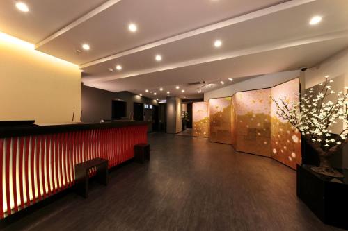 a lobby with a red bench and a red wall at Kuromon Crystal Hotel in Osaka