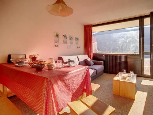 un salon avec une table et un canapé dans l'établissement Appartement Skis aux Pieds - Balcon Sud, 6 Pers., 1 Chambre, Wifi - FR-1-344-1049, aux Menuires