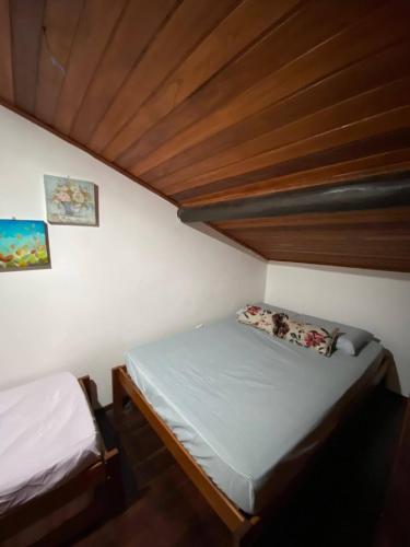 a small bedroom with a bed and a wooden ceiling at Winterville residence in Gravatá