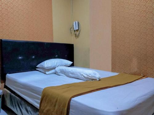 Un pat sau paturi într-o cameră la Hotel Fikry Toli Toli