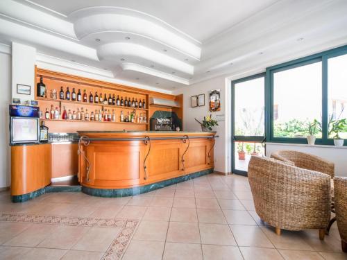 eine Bar mit einer Theke und Stühlen in einem Zimmer in der Unterkunft Flat in residence with swimming pool in Ricadi