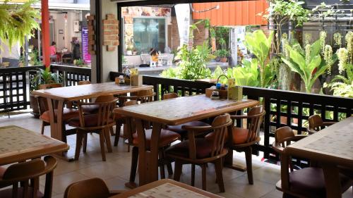 un ristorante con tavoli e sedie in legno e un patio di Klein Heidelberg Guesthouse a Pattaya North