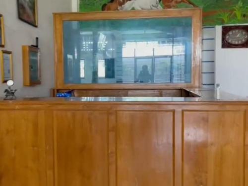 a kitchen with a wooden cabinet with a window at Hotel Lucky 21 Syariah Mitra RedDoorz in Tabahpingin