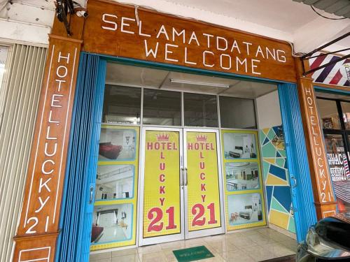 a store with a welcome sign on the front of it at Hotel Lucky 21 Syariah Mitra RedDoorz in Tabahpingin