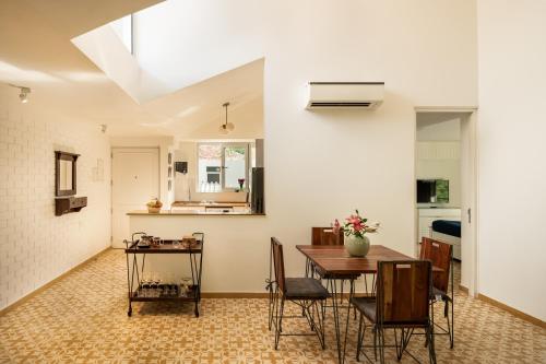a kitchen and dining room with a table and chairs at El Sereno 2 BHK Stylish Apartments In Vagator with Garden and Pool- 10 minutes drive to Vagator Beach in Chapora