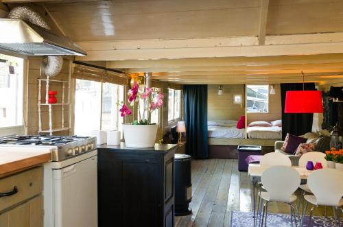 een keuken en een woonkamer met een bed in een kamer bij Houseboat Prince-Avalon in Amsterdam
