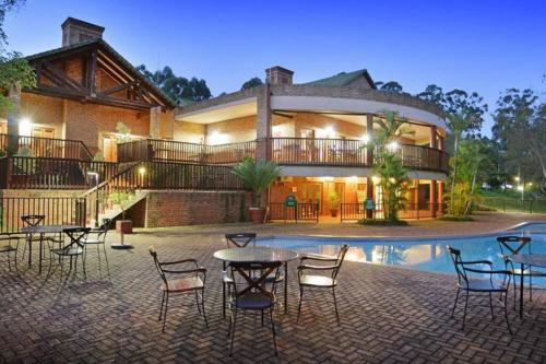 a house with a pool and tables and chairs at 3-Bedroom House, Greenway Woods, White River in White River