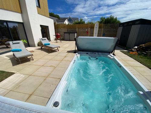 a hot tub in a backyard with two chairs at Aquanaut in Cowes