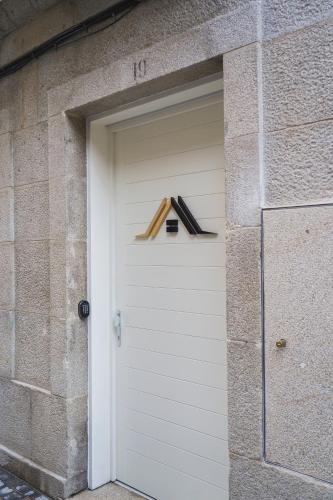 a white garage door with a number on it at Hostel Charino in Pontevedra