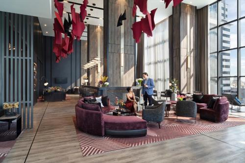 a lobby with couches and tables in a building at Ascott Embassy Sathorn Bangkok in Bangkok