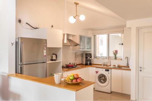 a kitchen with a bowl of fruit on a counter at El Sereno 2 BHK Stylish Apartments In Vagator with Garden and Pool- 10 minutes drive to Vagator Beach in Chapora