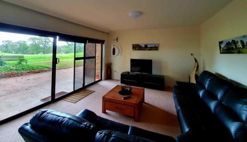 a living room with a couch and a coffee table at Shepparton Golf Motel in Shepparton