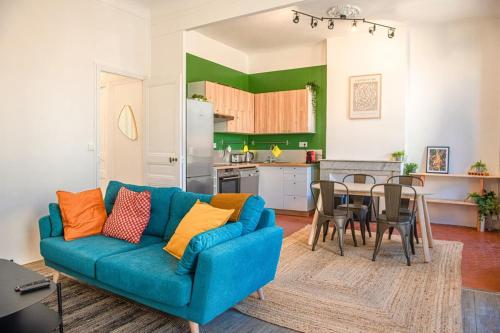 uma sala de estar com um sofá azul e uma mesa em Le Repaire - 2 chambres avec balcon em Marselha