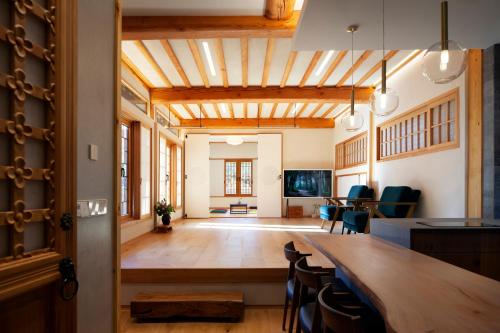 una sala de estar con una gran mesa de madera y sillas en IRIRU Luxury Hanok Stay - Eunpyung Hanok village en Seúl