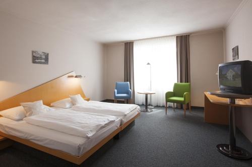 a hotel room with a bed and a tv at Golfhotel Fahrenbach in Tröstau