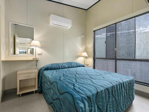 a bedroom with a bed and a large window at Ingenia Holidays Noosa North in Tewantin