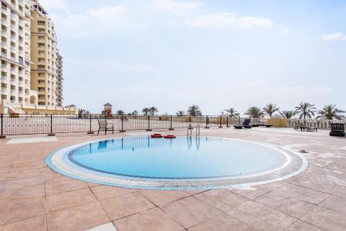 a large swimming pool in a courtyard with buildings at Live and experience a stunning Sea View Studio in Ras al Khaimah
