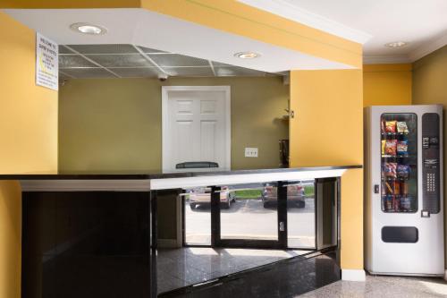 a kitchen with a counter and a refrigerator at Super 8 by Wyndham Indianapolis-Southport Rd in Indianapolis