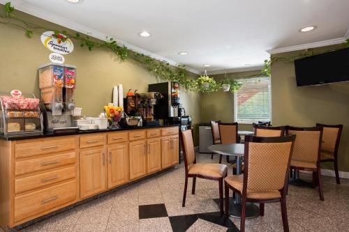 a restaurant with a counter and a table and chairs at Super 8 by Wyndham Indianapolis-Southport Rd in Indianapolis