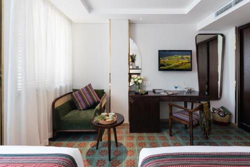a hotel room with a couch and a table and a mirror at Au Lac Legend Hotel in Ho Chi Minh City