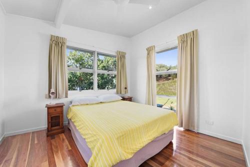 una camera bianca con un letto e due finestre di DOLCE VILLA a Tangalooma