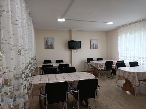 a conference room with tables and chairs and a tv at Гостевой дом Коль-тор in Kegeti