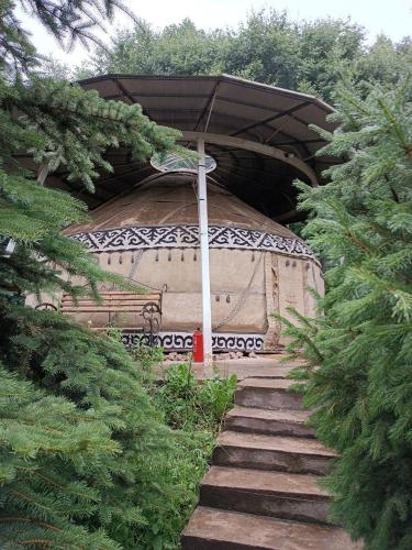 a stone path with an umbrella in a garden at Гостевой дом Коль-тор in Kegeti
