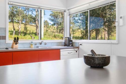 a kitchen with a counter with a sink and two windows at Yarramie in Mount View