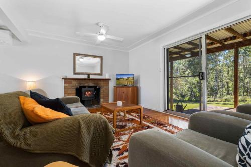 a living room with two couches and a fireplace at Yarramie in Mount View