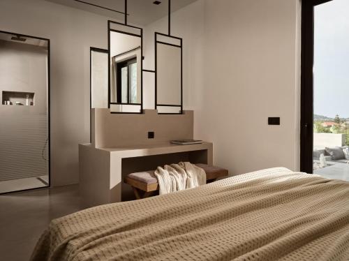 a bedroom with a bed and a vanity and mirrors at Yliessa - Luxury pool villa surrounded by nature in Dhrákas