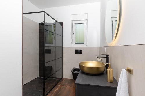 a bathroom with a gold sink and a shower at Villa L&L in Medulin