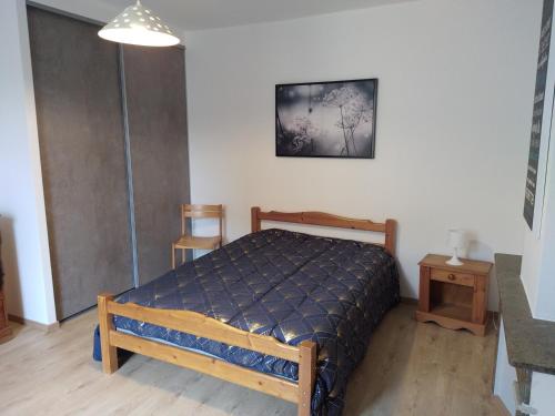 a bedroom with a bed with a blue comforter at Maison de village confortable entièrement rénovée in Saint-Just
