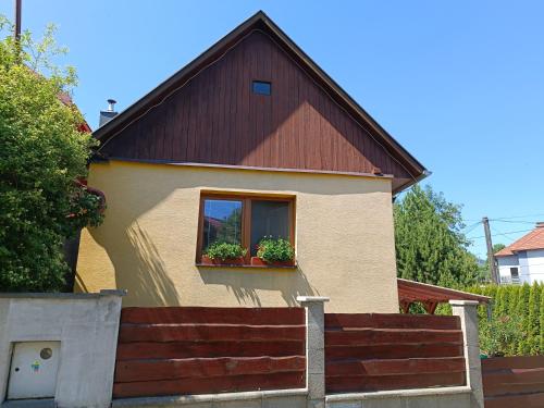 a house with a window with potted plants in it at Útulný dovolenkový dom in Liptovský Hrádok