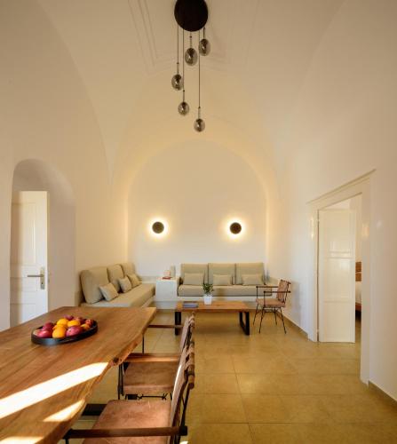 a living room with a table and a couch at Diva Santorini Luxury Villa in Pirgos
