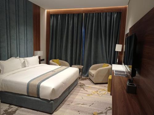 een hotelkamer met een bed en een televisie bij Rosa Grand Hotel in Riyad