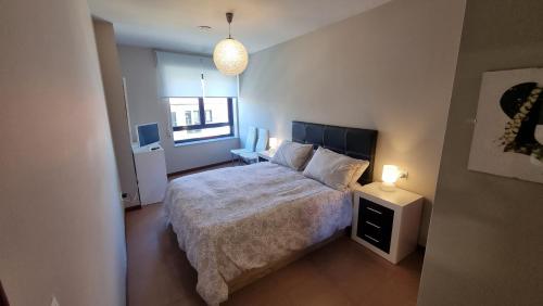 1 dormitorio con cama y mesita de noche con lámpara en Coira Dream a 100 metros de la playa de Portosín, en Portosín