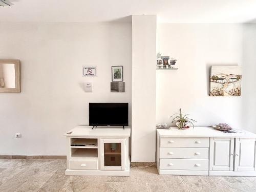 a living room with a tv and a white dresser at Jazmín Apartamentos Centro in Málaga