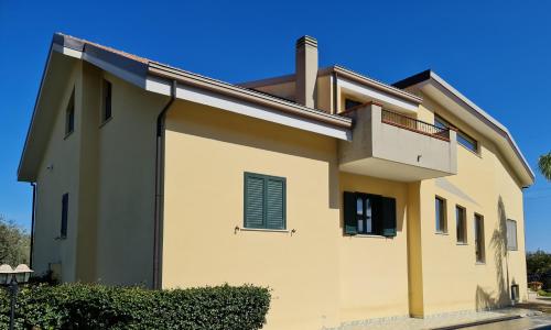 a white house with a window and a balcony at Villa Toti in Montepaone