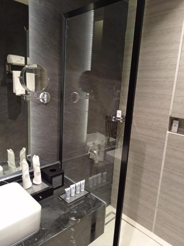 a bathroom with a shower and a white sink at Rosa Grand Hotel in Riyadh