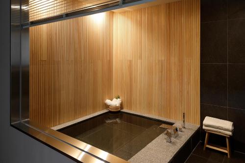 a bathroom with a sink and a glass wall at Hotel Foret The Spa in Busan