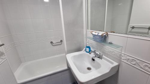 y baño blanco con lavabo y ducha. en Coira Dream a 100 metros de la playa de Portosín, en Portosín